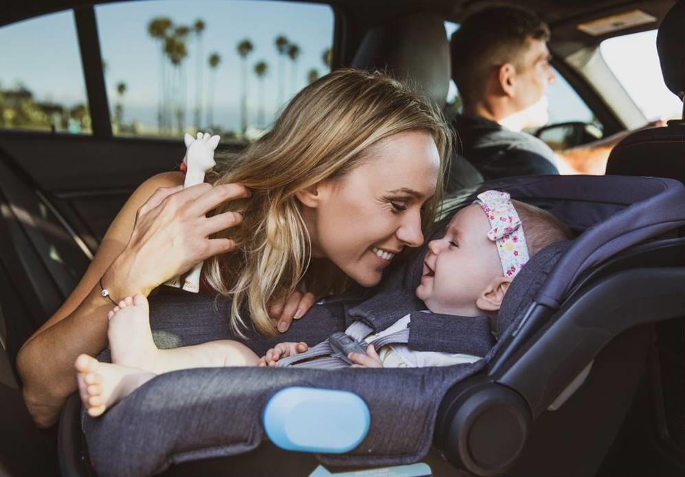 Niemowlak zapięty tyłem do kierunku jazdy, system isofix w samochodzie, mama z dziegciem w bezpiecznej podróży